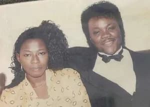 A vintage photograph featuring a young man who appears to be Ghanaian highlife legend Daddy Lumba alongside a woman, likely Akosua Serwaa. The man is dressed in a formal black suit with a white shirt and black bowtie, while the woman wears a cream-colored blouse with a dark geometric pattern.