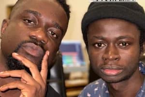 Ghanaian music stars Sarkodie and Safo Newman are pictured together in a close-up selfie, likely taken in a recording studio. Sarkodie is seen on the left with his hand on his chin, while Safo Newman wears a black beanie on the right, with music production software blurred in the background.