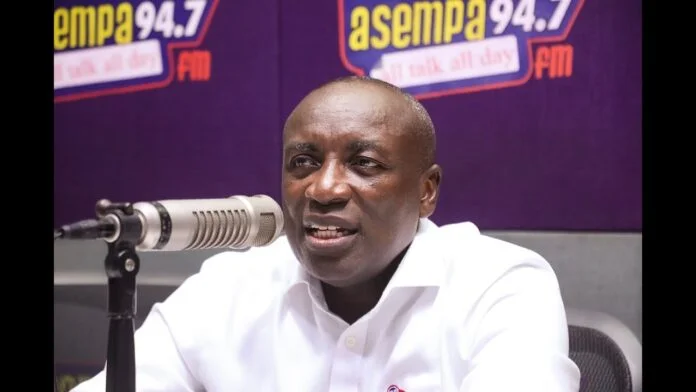 A photograph of Ghanaian politician Kwabena Agyepong during an interview in a radio studio. He is speaking into a professional microphone with the Asempa 94.7 FM logo visible on the purple background behind him.