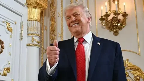 AFP via Getty Images US President Donald Trump gives a thumbs up as he arrives at a dedication ceremony for Southern Boulevard, in the ballroom at Mar-a-Lago in Palm Beach, Florida, on January 16, 2026.