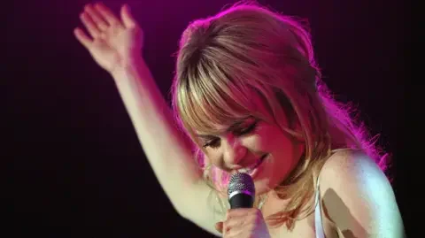 Duffy on stage with a microphone