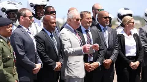 Reuters The King stands in front of a group of officials as he prepares to take a photo