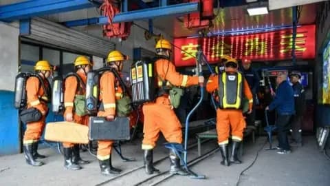 Xinhua Rescue workers in orange gear entering industrial facility with equipment and breathing apparatus.