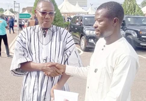 Dr Clement Abas Apaak (left), Deputy Minister for Education, presenting a cash donation to Yussif Abdul Fatawu, the teacher, in Bolgatanga