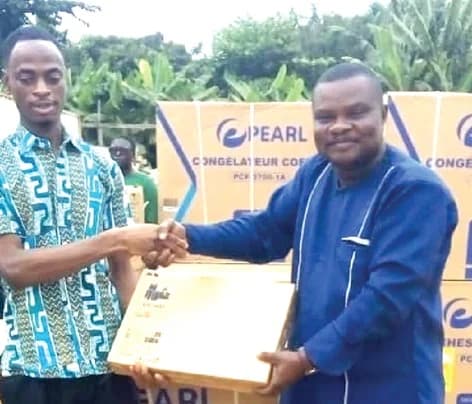 Nicholas Owen Korletey (right), Presiding Member for the Shai-Osudoku District Assembly, presenting a laptop to Maxwell Tettey