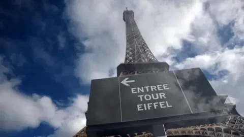 Reuters The Eiffel Tower is seen from the base of the monument with clouds and blue skies around it