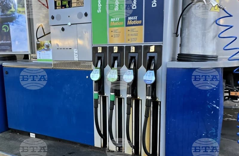 A close-up photograph of a fuel dispenser at a gas station featuring four pump nozzles for Super and Diesel fuels. The unit displays 'Maxx Motion' branding and includes a digital screen showing transaction details, with a Bulgarian News Agency (BTA) watermark layered across the image.