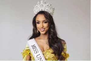 A portrait of a beauty queen wearing an ornate silver crown and a gold embellished gown. She is wearing a white sash with the text MISS UN visible, identifying her as a pageant contestant, likely linked to the Miss Universe Jamaica lawsuit mentioned in the article context.