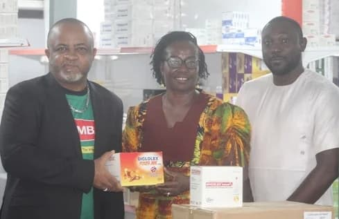 Eddy Blay (left), Brand Communications representative, assisted by David Tattari (right), Executive Assistant, both from Unichem Ghana Group, presenting the drugs to Yvonne Dasoberi, an Assistant Corporate Communications Officer of the GCGL