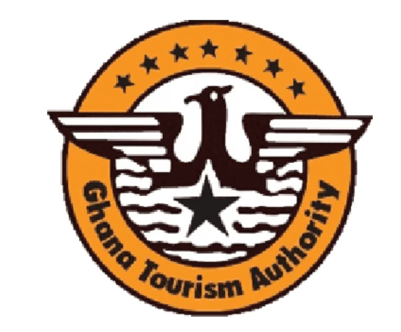 The official logo of the Ghana Tourism Authority is displayed, featuring a circular orange emblem with an eagle and a black star. The words 'Ghana Tourism Authority' are curved along the bottom of the logo, while seven small stars arc across the top.
