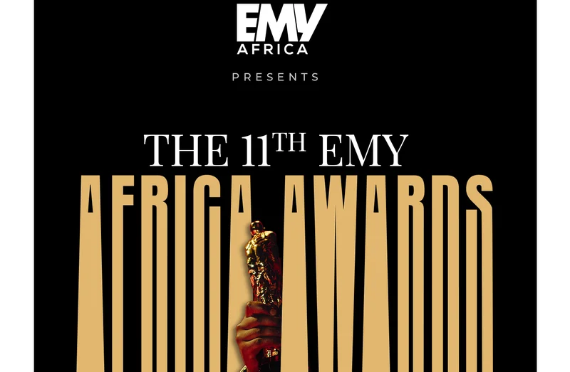 A promotional graphic for the 11th EMY Africa Awards featuring gold and white typography on a solid black background. The design prominently displays a hand holding a golden trophy statuette centered behind the words 'AFRICA AWARDS' in an elongated font.
