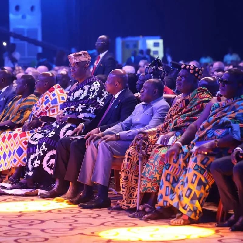 President John Dramani Mahama is seated among traditional Ghanaian rulers and other dignitaries at a formal indoor event. The gathering highlights a significant cultural and political intersection, with attendees dressed in elaborate Kente and Adinkra textiles under blue stage lighting.
