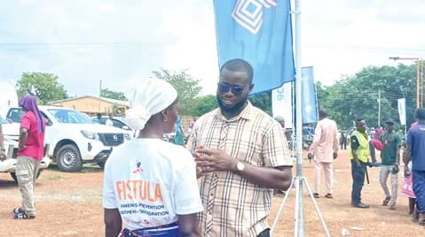 The reporter interacting with Seidu Amina, fistula survivor
